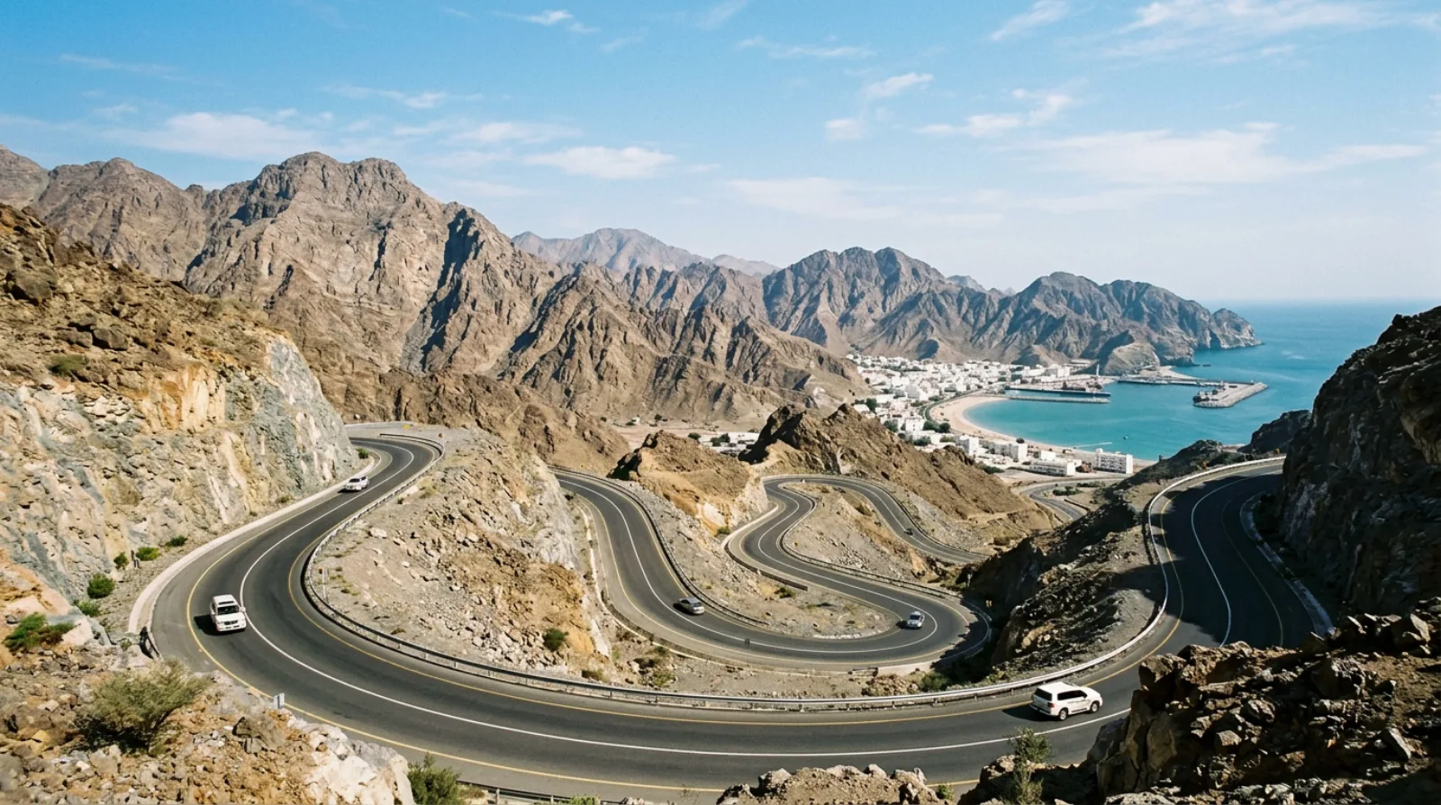 Scenic mountain road winding through the Hajar Mountains leading to Khorfakkan
